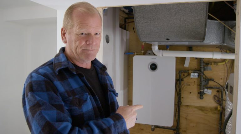 Mike Holmes with Bosch Greentherm-9900i-SE Tankless Water Heater installed on job site.