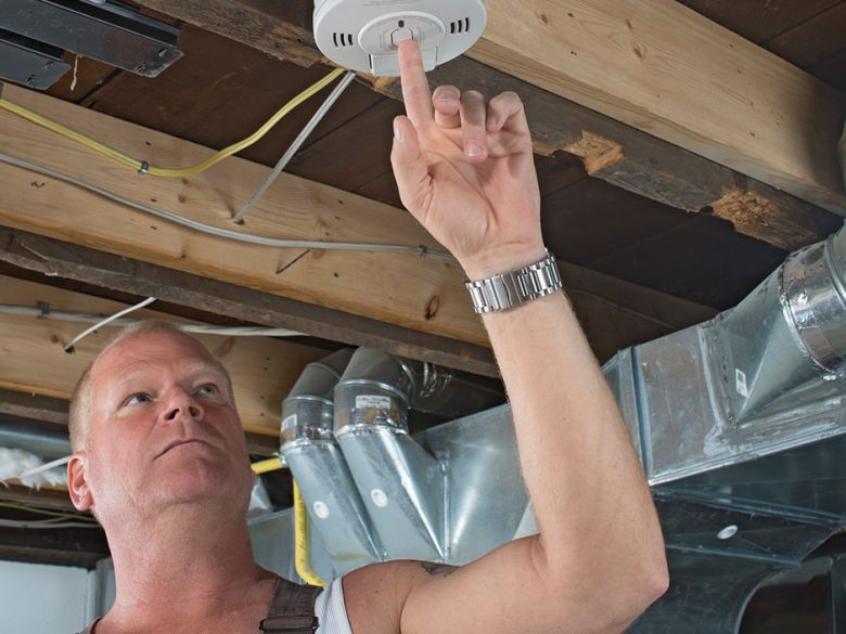 Mike Holmes with smoke detector.