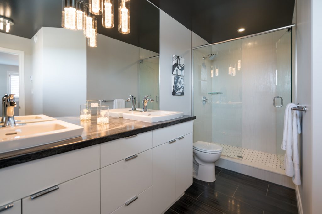 Hanging pendant lighting and pot lights provide function and ambiance to this bathroom by Duvanco Homes.