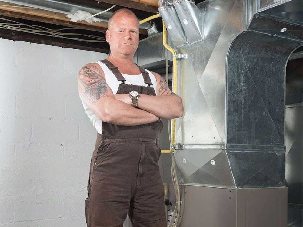 Mike Holmes in front of a furnace