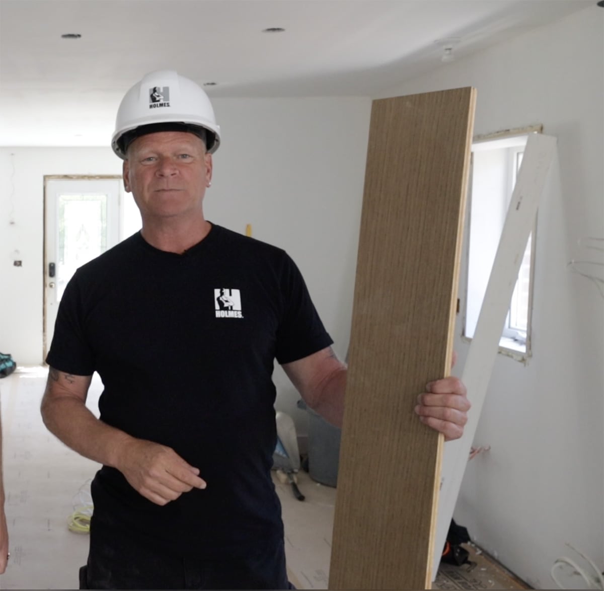 Mike Holmes installing flooring on project.