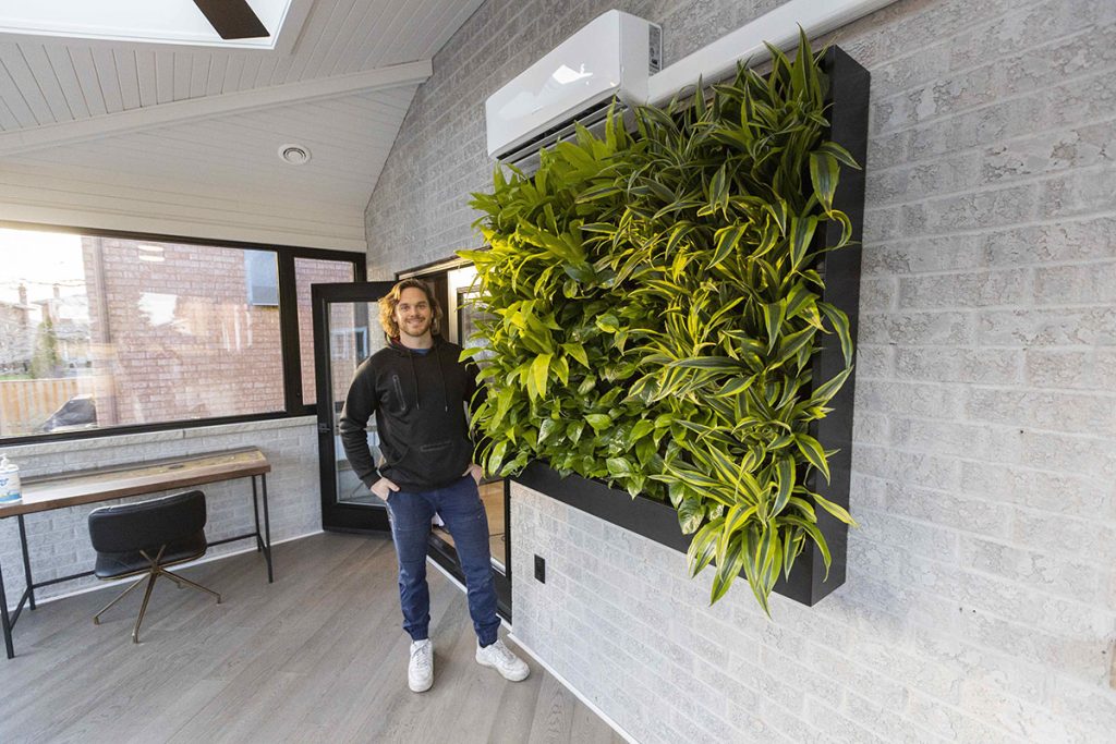 Mike Holmes Jr. next to a “living wall” installed in Frank Cozzolino’s sunroom, with a Bosch mini-split heat pump so this room can be enjoyed all year long!