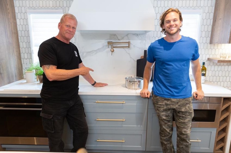 Mike Holmes and Mike Holmes Jr standing in front of Invisiacook countertop from Ciot in Noah's house on Season 1 of Holmes Family Rescue. 