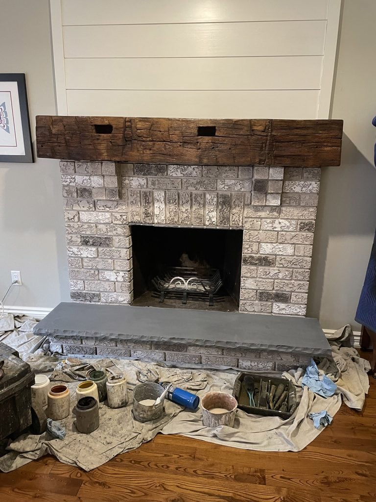 A fireplace staining project by Permatint, is almost complete, note the various colored tints used.