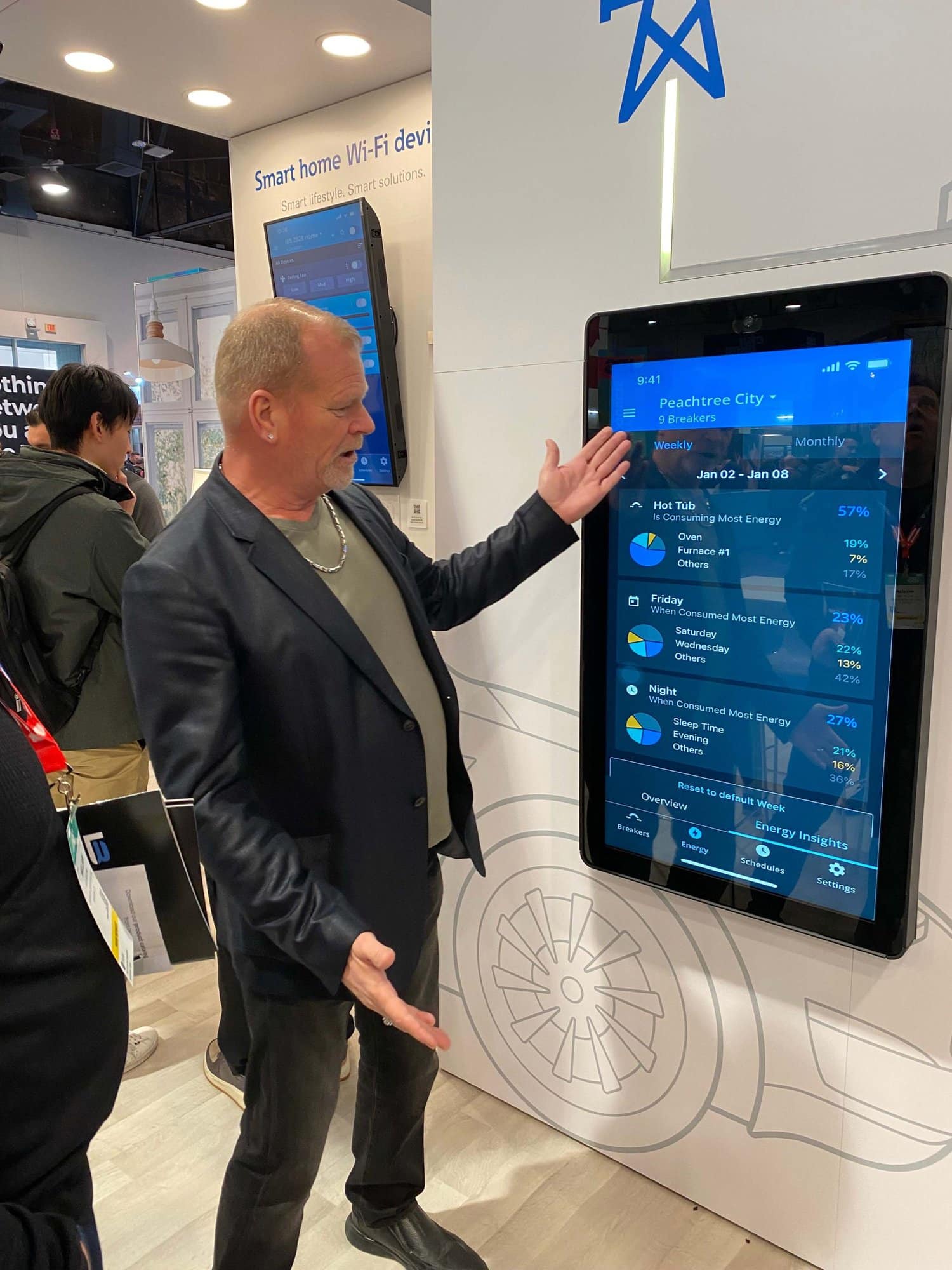 Mike Holmes looking at the Eaton smart home app showing the energy usage measured by the smart breaker.
