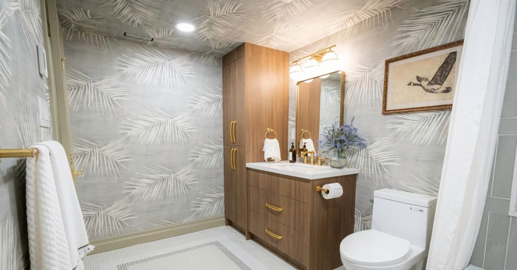 Wallpaper Ideas From Mike Holmes Projects. Light grey wallpaper with oversized leafs for an at-home feel in this bathroom project.